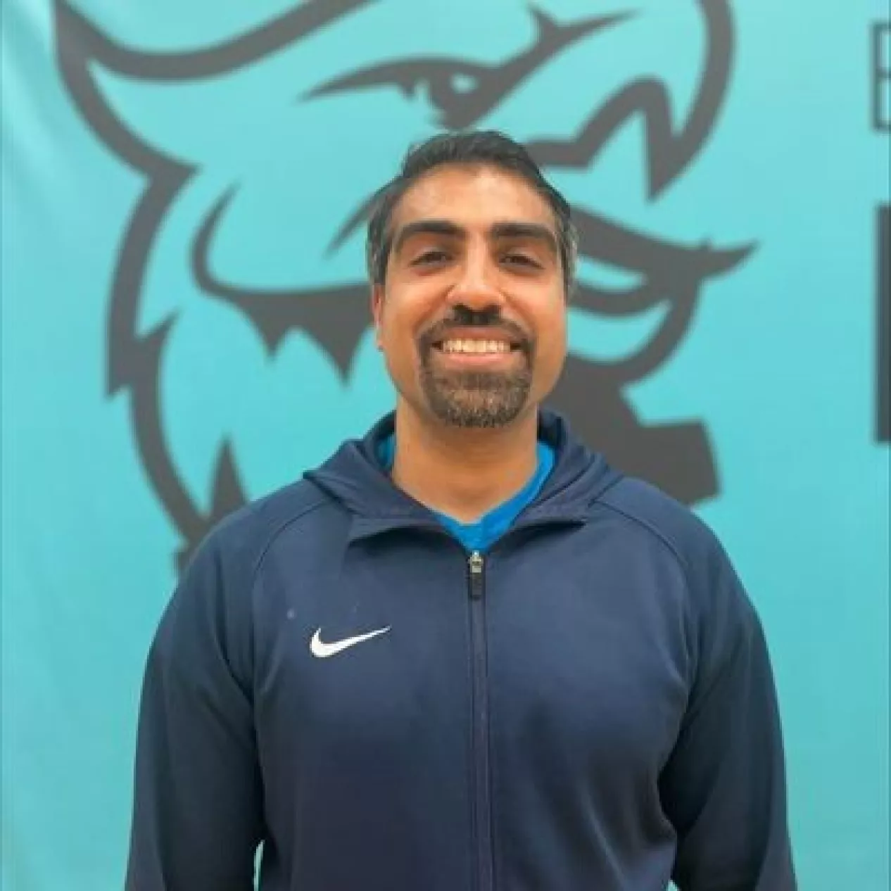 Khalid Yacoob smiling in front of the East London sports phoenix