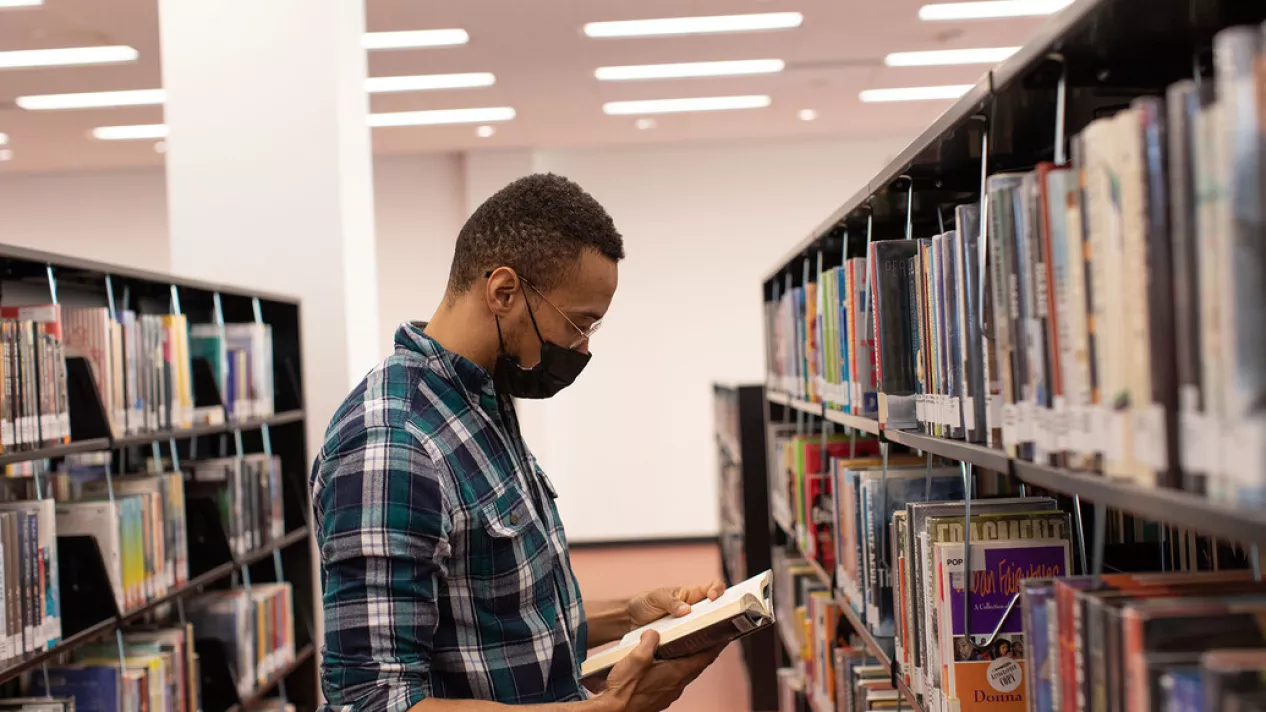 Man in library looking at books