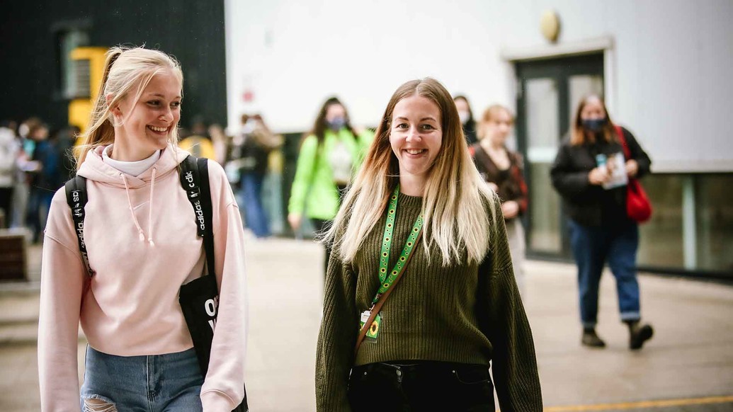 Two female students smiling at open day