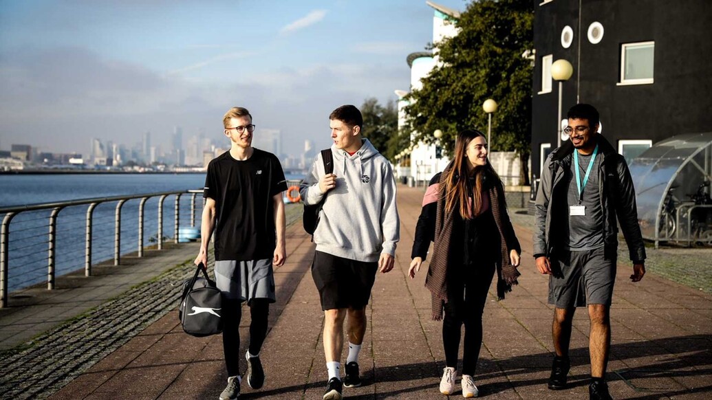 Students walking on Docklands Campus riverfront on campus tours