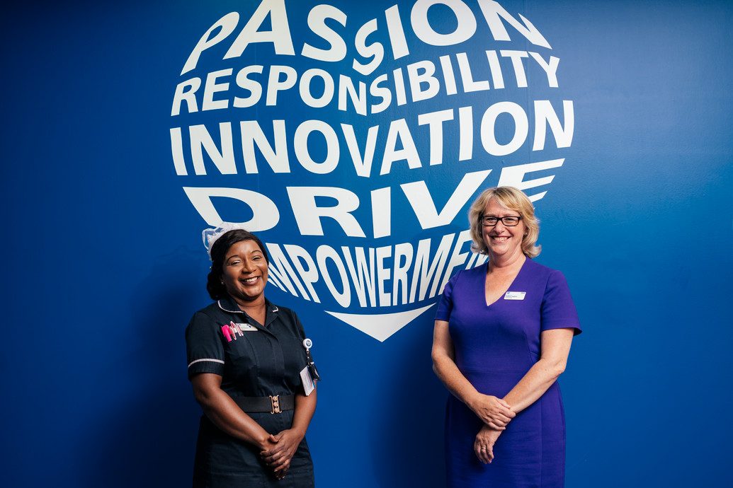 Two nurses standing in front of a poster