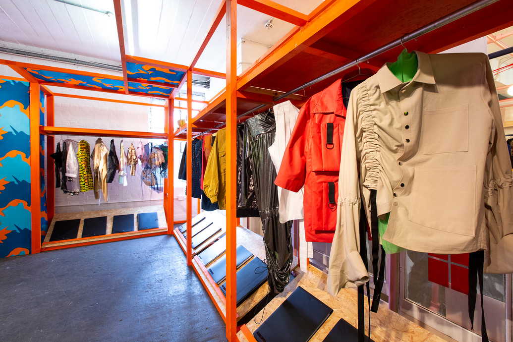 The image shows clothes hanging up in a wardrobe