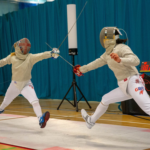 Two fencers attacking with their fencing swords.