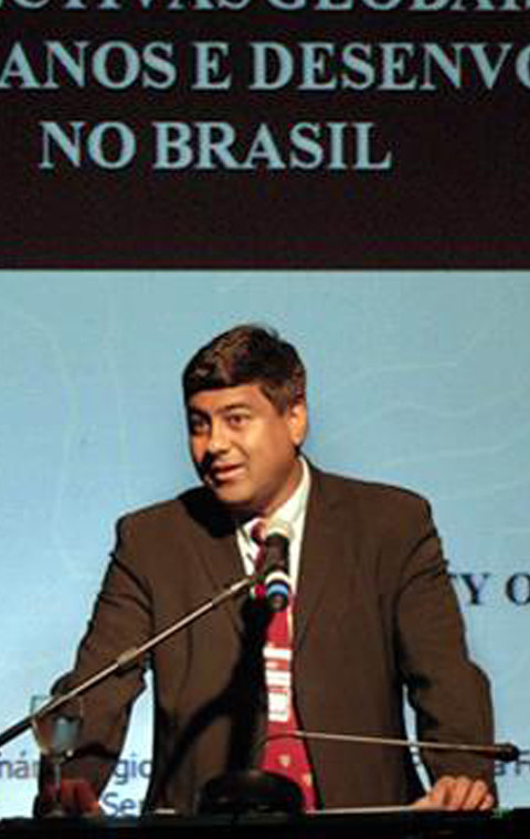 Image of Prof Sait speaking in front of a microphone