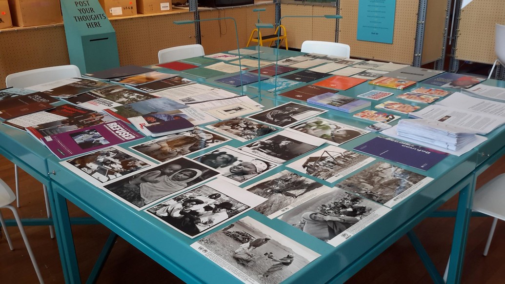 A table covered in different black and white photographs of various scenes.