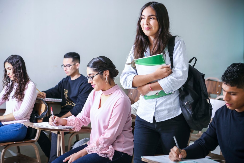 Student standing in class, surrounded by students seated